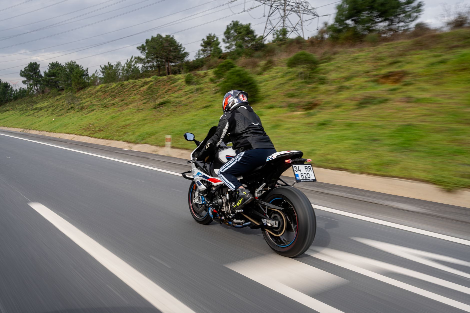 Person riding a motorcycle on a highway, showcasing speed and adventure.
