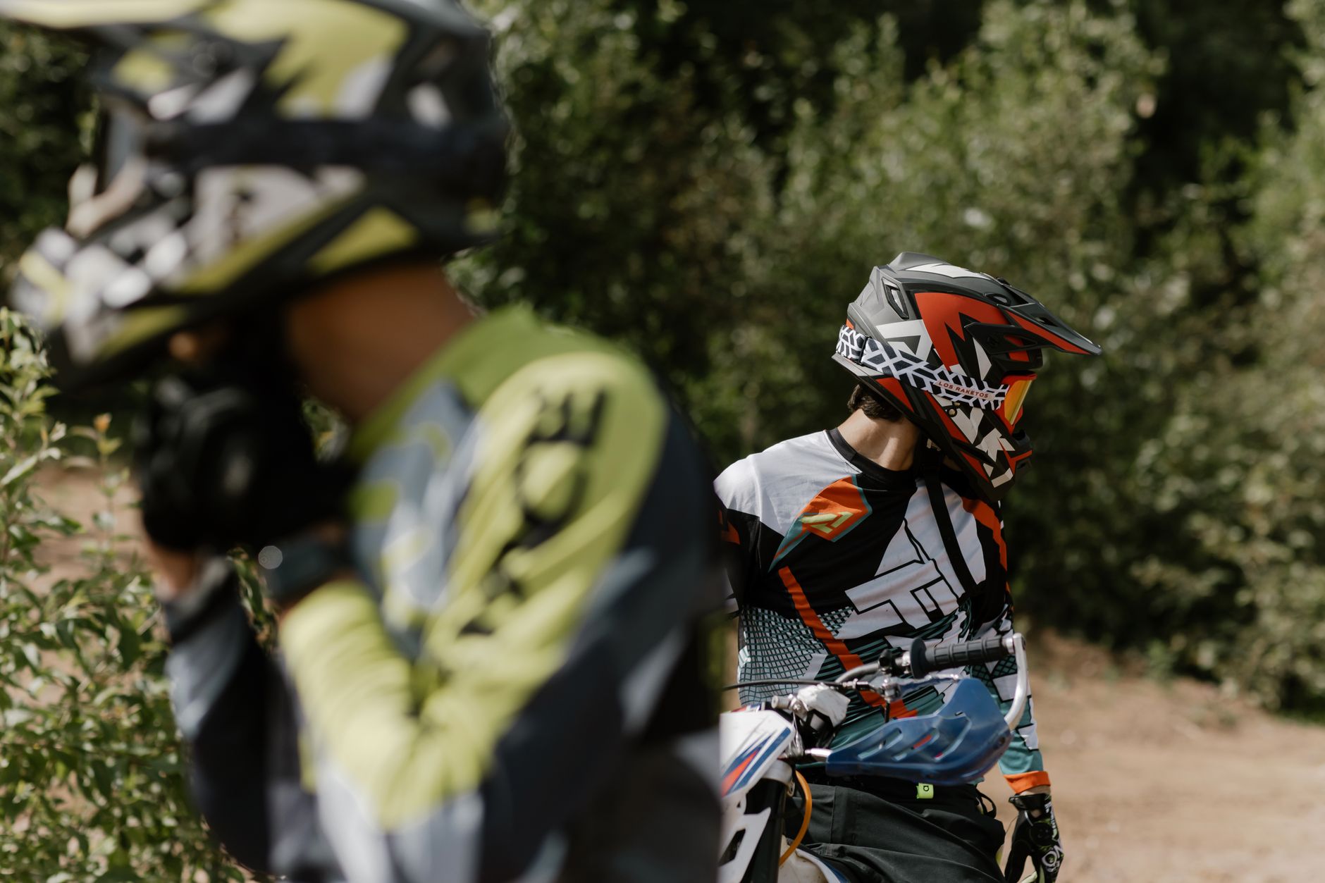 Two motorcyclists in protective gear and helmets riding outdoors. Perfect for adventure themes.