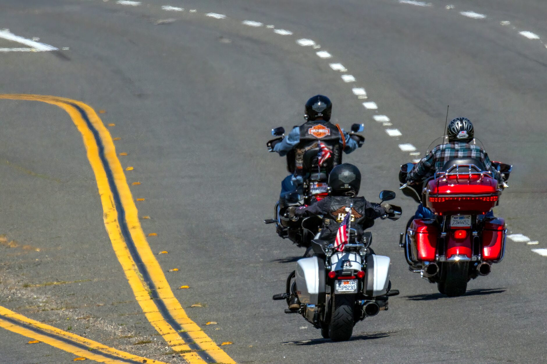 Three motorcyclists riding freely on a highway, enjoying the thrill of the open road.