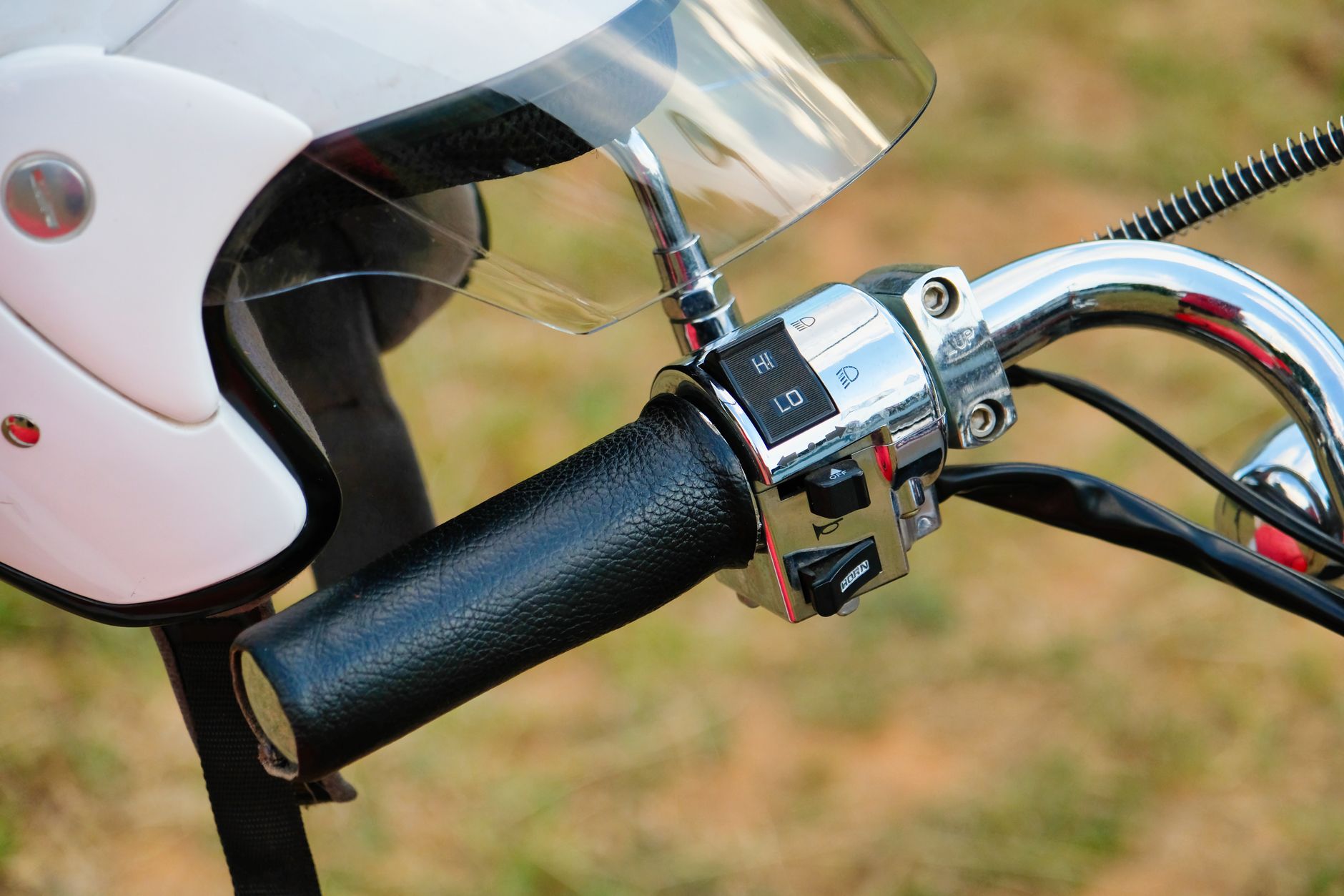 Detailed shot of a motorcycle handlebar and helmet on a sunny day in South Africa.