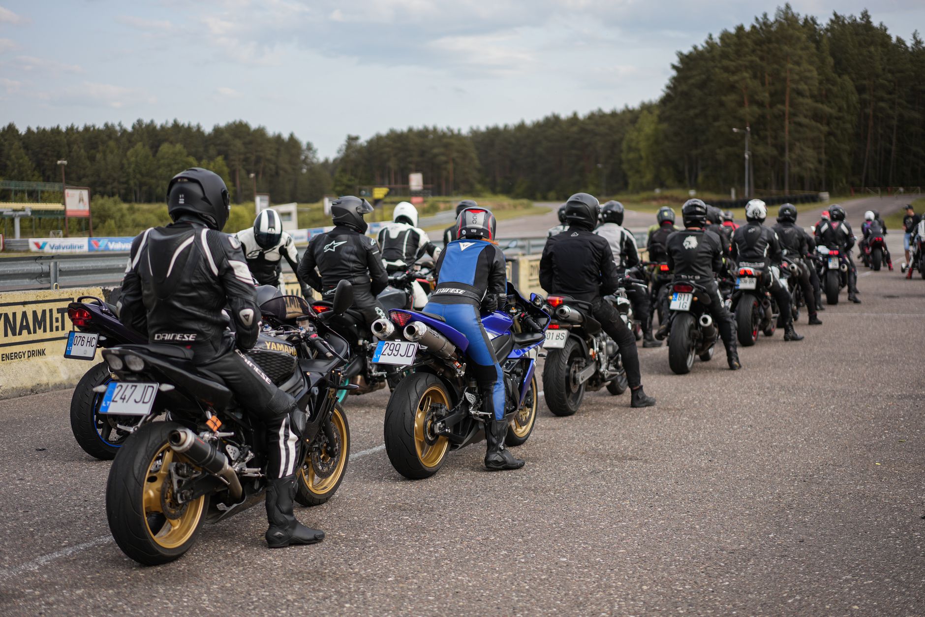 Group of motorbike riders lined up for an exciting track day at the racetrack.