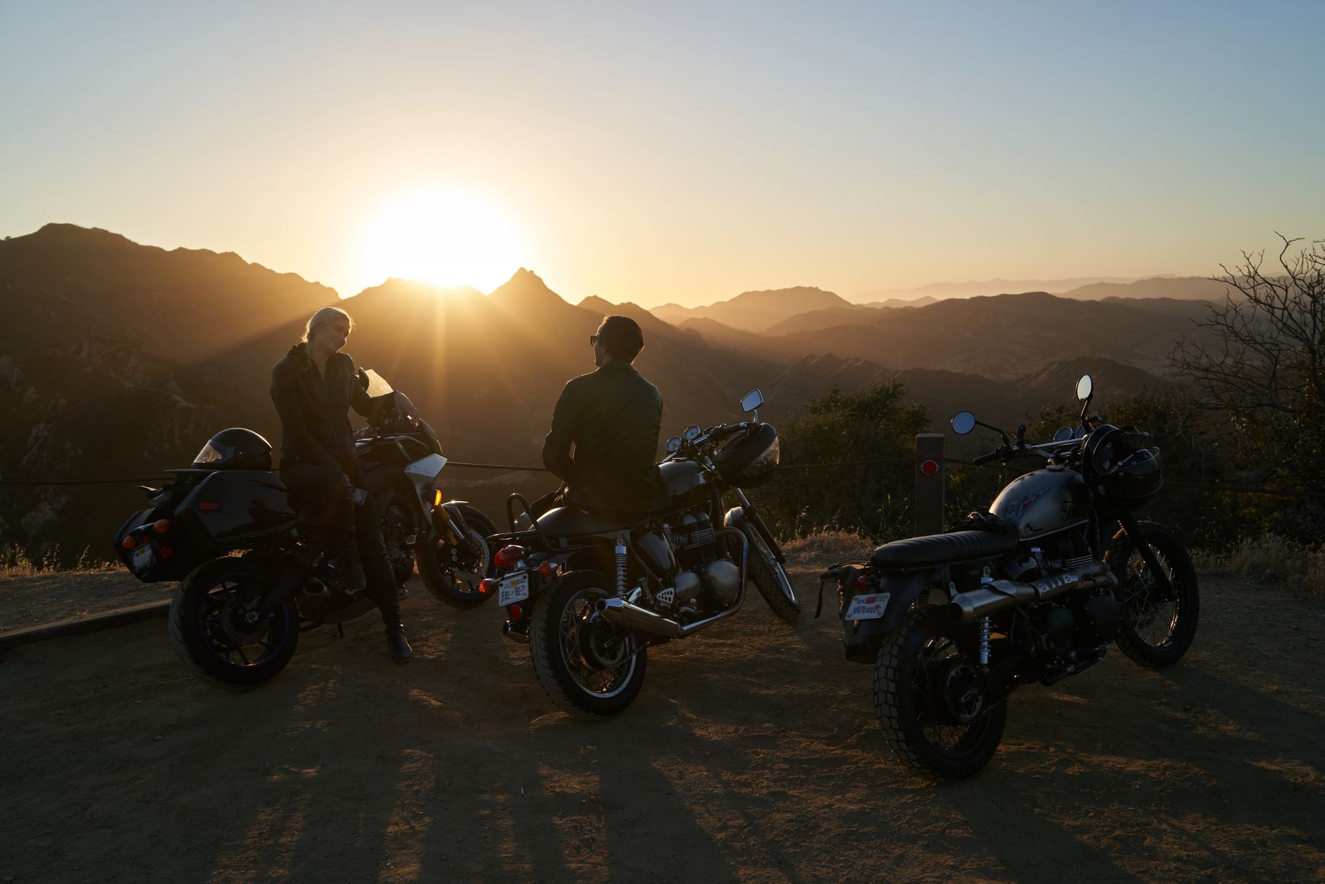 Motorcyclists enjoy a scenic sunset view in the mountains, embodying freedom and adventure.