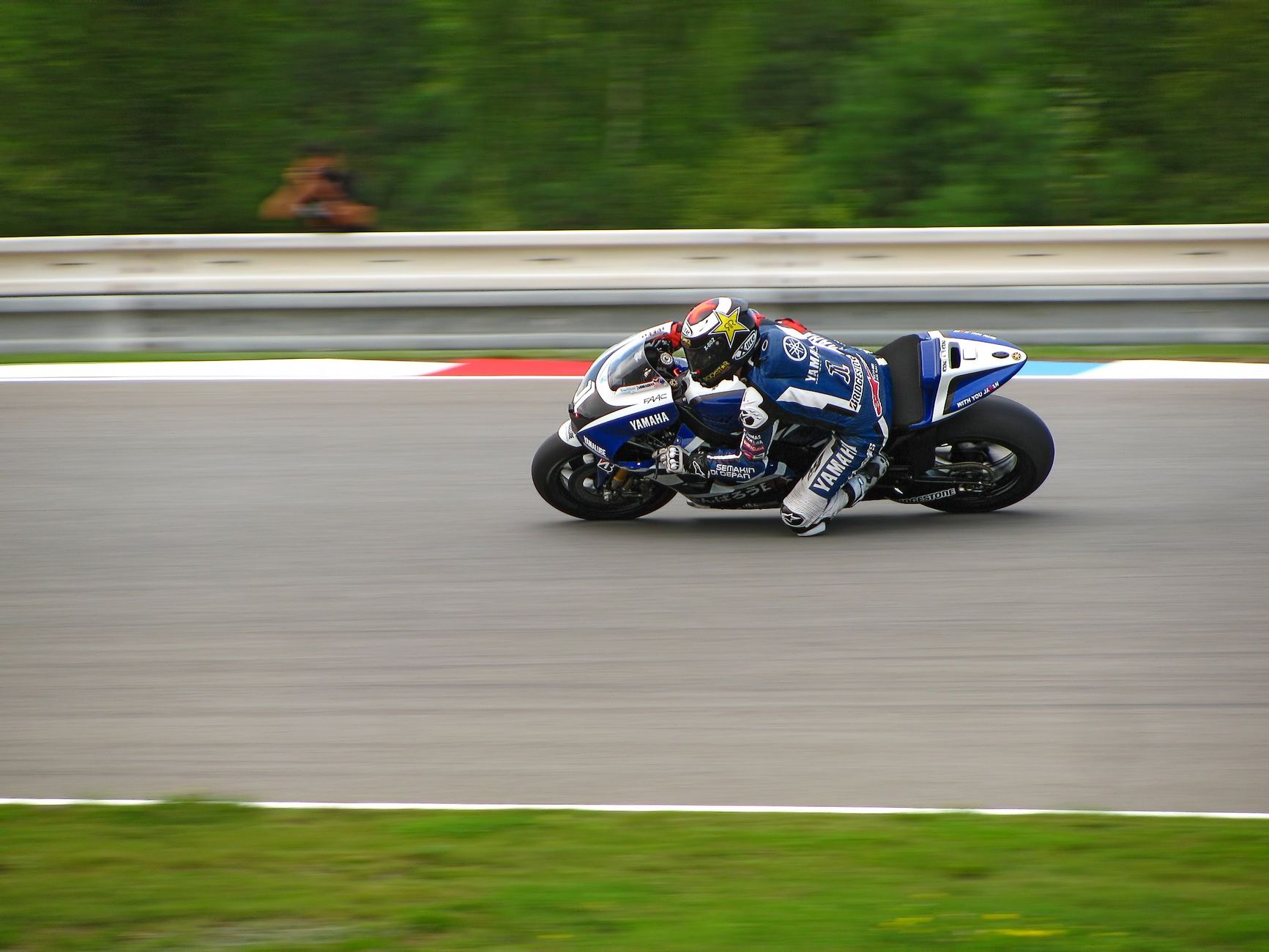 Dynamic shot of a professional motorcycle racer speeding on a track during a competition.