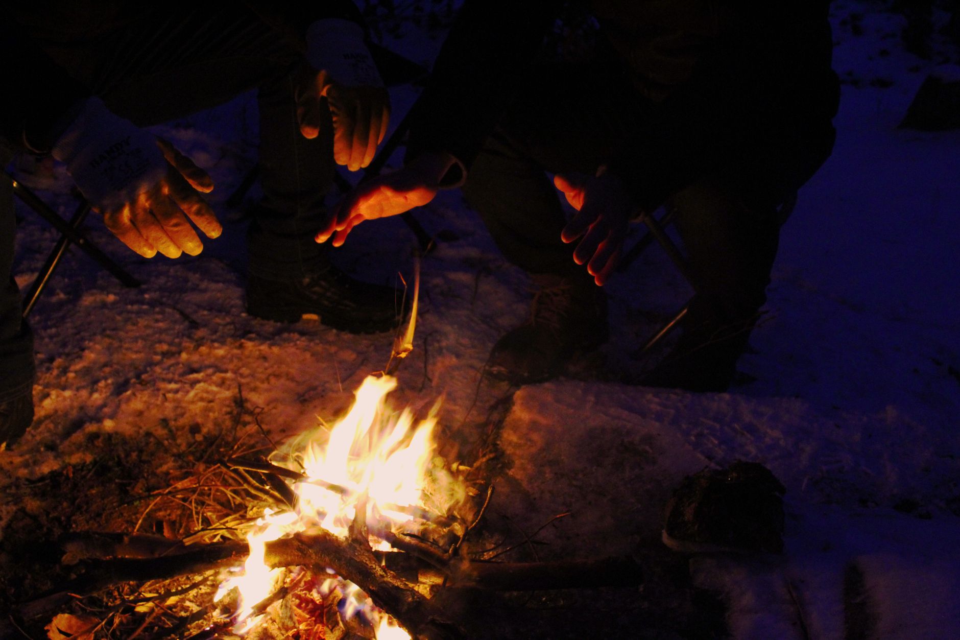 Warming hands by a campfire on a snowy night in Balıkesir, Turkey.