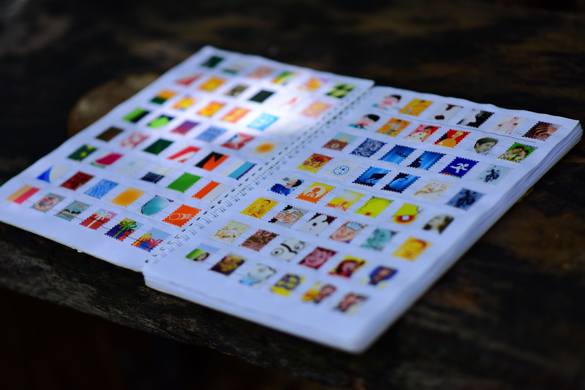 Colorful stamp collection displayed in an open album on a wooden table.
