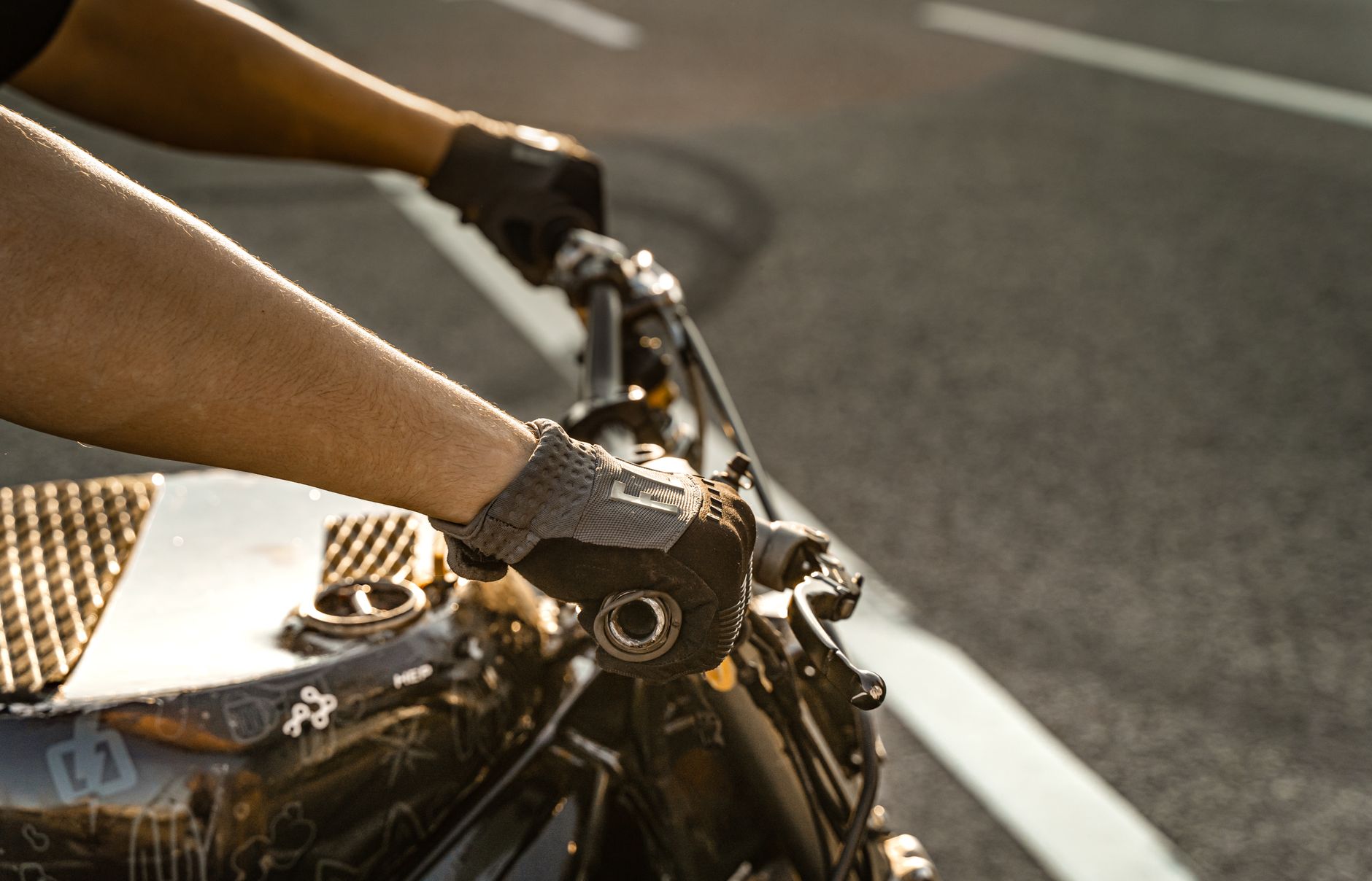 Close-up of motorcyclist's hands on handlebars, capturing motion and adventure.
